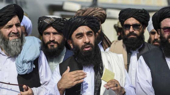 Taliban spokesman Zabihullah Mujahid (C) addresses a media conference at the airport in Kabul on August 31, 2021. - The Taliban joyously fired guns into the air and offered words of reconciliation on August 31, as they celebrated defeating the United States and returning to power after two decades of war that devastated Afghanistan. (Photo by WAKIL KOHSAR / AFP)