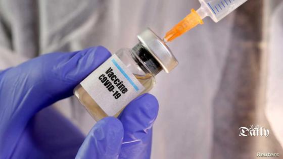 FILE PHOTO: A woman holds a small bottle labelled with a "Vaccine COVID-19" sticker and a medical syringe in this illustration taken April 10, 2020. REUTERS/Dado Ruvic/Illustration/File Photo