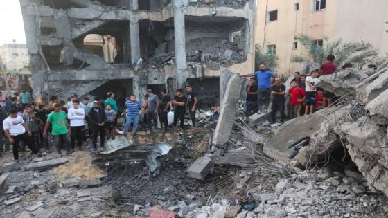 People gather as Palestinians work to remove casualties from under the rubble of a house destroyed by Israeli strikes, in Khan Younis in the southern Gaza Strip October 17, 2023. REUTERS/Ahmed Zakot