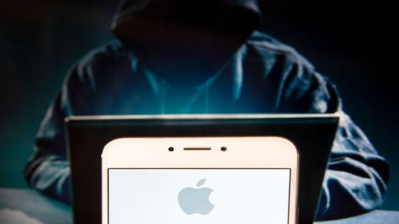 HONG KONG, CHINA - 2018/12/02: In this photo illustration, the American multinational technology company Apple logo is seen displayed on an Android mobile device with a figure of hacker in the background. (Photo Illustration by Miguel Candela/SOPA Images/LightRocket via Getty Images)